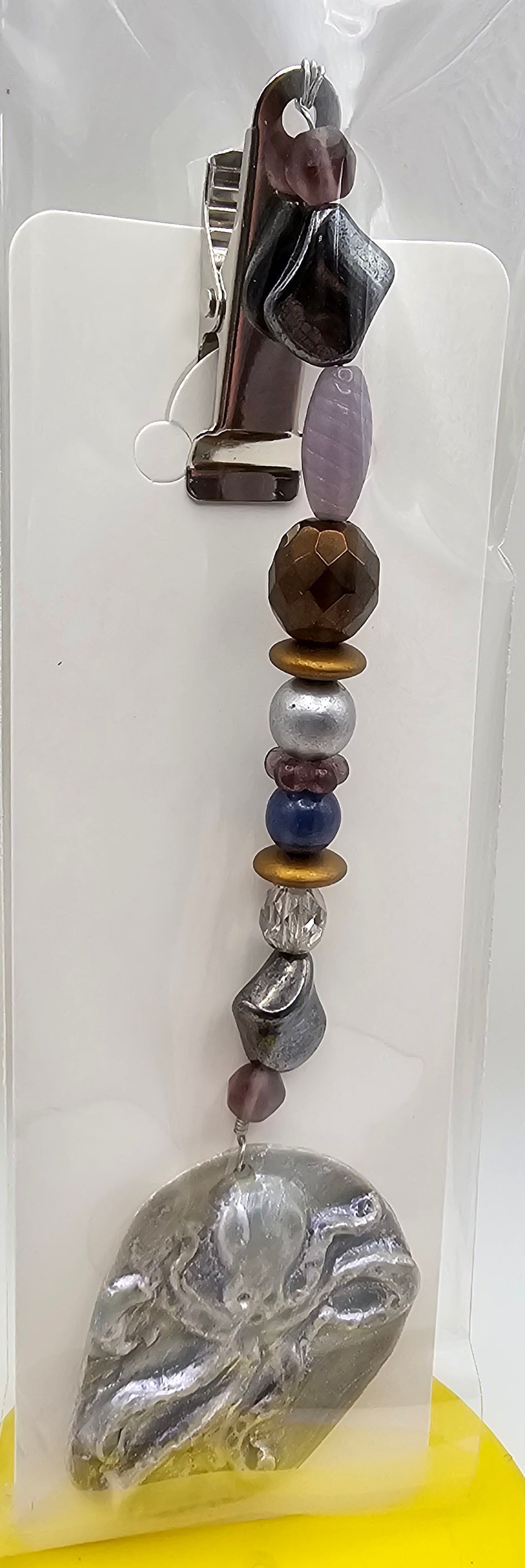 Decorative hair clip with beads and a crystal on a white card