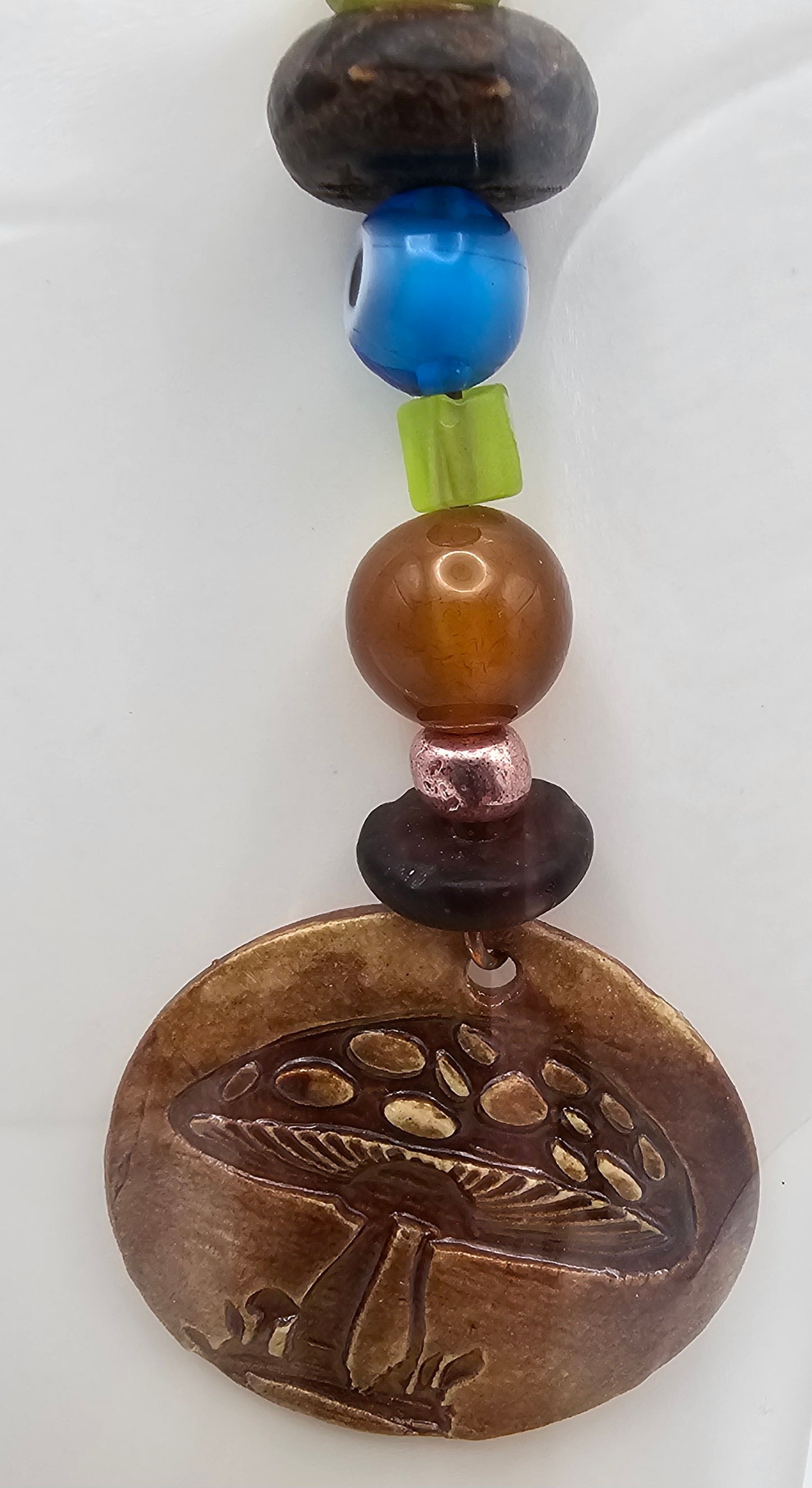 Beaded charm with a mushroom design on a white background
