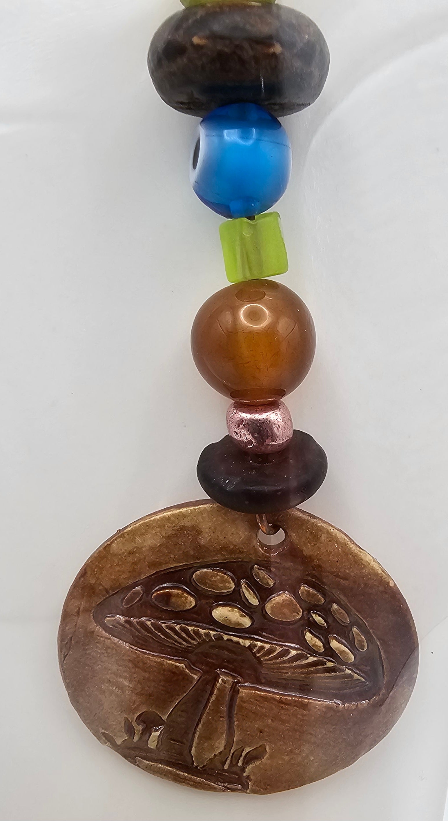 Beaded charm with a mushroom design on a white background